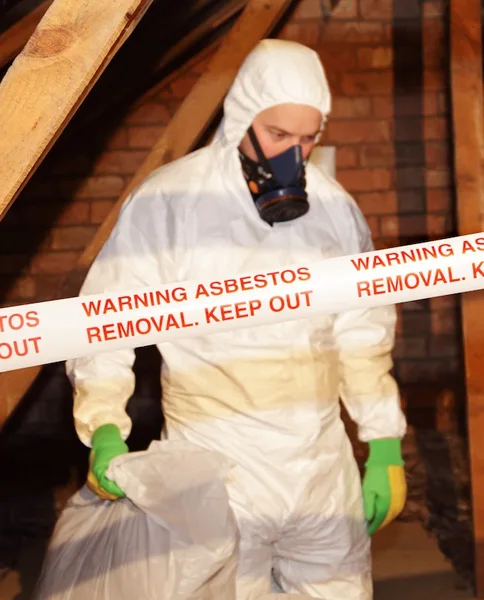 Asbestos removal worker with warning tape